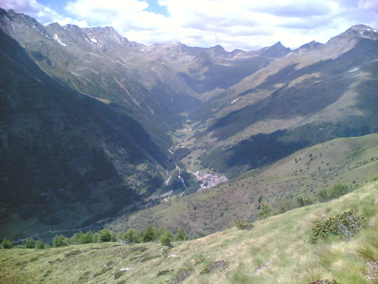 Veduta della Valle delle Messi tra pendii erbosi e montagne